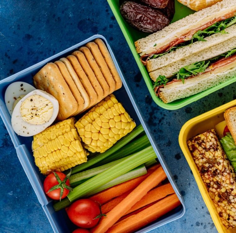 Colorful lunchboxes featuring sandwiches, vegetables, and snacks for healthy eating.